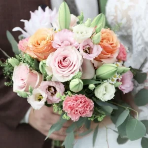 Zarter Brautstrauß mit rosa Rosen, Wiesenblumen und grünen Blättern